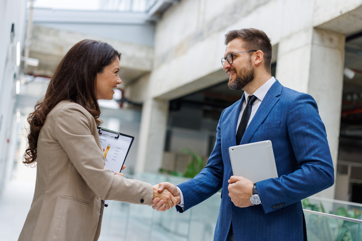 Business colleagues shaking hands in a modern office building
